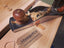 Wooden plane tool on a wooden surface with Mungo & Co branding.